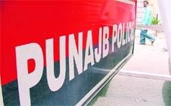 A police barricade on the Malhar road bears the wrong spelling of Punjab.