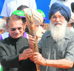 Punjab Governor Shivraj Patil hands over the Queens baton for Commonwealth Games to CM Parkash Singh Badal at the Wagah border on Friday.
