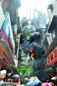 Smoke and flames emanate from a three-storeyed shop selling plastic items at Attari Bazaar in 