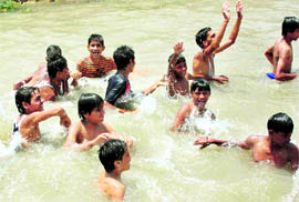 Boys having fun while bathing in a canal in Jammu