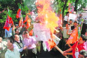 Workers of the BJP shout slogans as they burn an effigy of the UPA government during a demonstration against fuel hike at Shimla