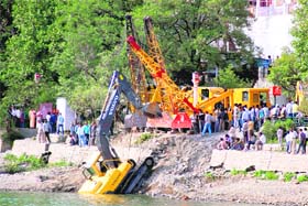Cranes retrieve an excavator from the Naini Lake