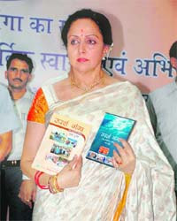 Hema Malini with copies of a book and a CD on the Sparsh Ganga project in Dehradun