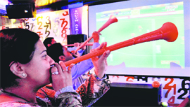 Fans blow vuvuzelas while watching a World Cup football match on large screen at a hotel in Chandigarh 