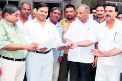 Former legislator Ambrish Kumar hands out a memorandum to an official in Haridwar on Monday.