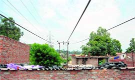A high-tension wire hangs a few feet above a house where a labourer died in Dehradun on Monday