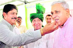 INLD Secretary-General Ajay Singh Chautala offers sweets to Rajya Sabha nominee Ranbir Singh Gangua as party chief Om Prakash Chautala looks on in Chandigarh