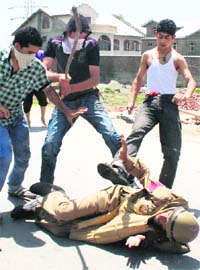 A policeman under attack during a clash near Narbal on Srinagar-Baramulla national highway