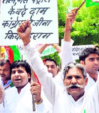 Activists of the Samajwadi Party raise anti-government slogans during a protest against increase in fuel prices for the second time in six months, in New Delhi on Sunday