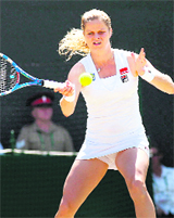 Belgiums Kim Clijsters returns the ball to Justine Henin during the Wimbledon Championships in southwest London on Monday.