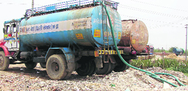 Water tankers being filled from an illegal borewell near Bajghera village in Gurgaon district.