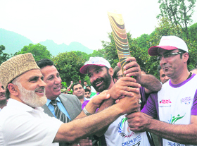 MInisters Ali Mohammad Sagar (extreme left) and RS Chib hand over the Queens Baton of Commonwealth Games to former Indian football team captain Majeed Kakroo (third from left) and former Skiing Olympian Gul Mustafa at Nishat Garden in Srinagar on Tuesday