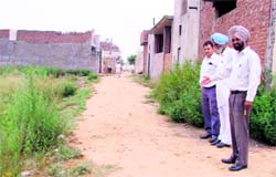 Residents of Passey Nagar show the bad condition of a road