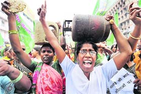 RJD supporters raise slogans as they carry chullahs and LPG cylinders during a protest rally against the price hike in cooking gas, in Patna