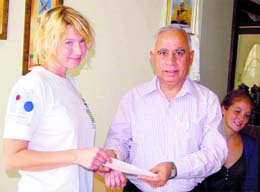 Jodie Underhill, the garbage girl, receiving a cheque from KL Manuja, a representative of the Rayat-Bahra Group, at Dharamsala on Wednesday. 