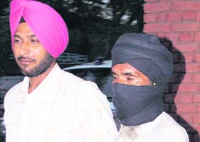 Sher Singh (face covered) is taken to court in Amritsar