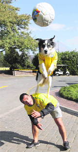 A Brazilian fan and his dog play with a soccer ball outside a hotel in Johannesburg