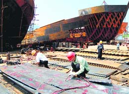 Chinese labourers work at state-owned shipyard in Yichang, central China's Hubei province on Thursday. China said on Friday its economy had expanded by 9.1 per cent in 2009 in an upward revision that narrows the gap even further with the world's number two economy Japan.