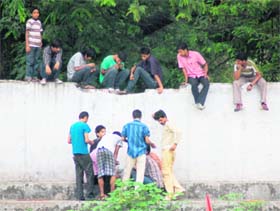 A group of gamblers enjoy the game at Pavillion Grounds as others watch them sitting on a wall in Dehradun on Thursday.