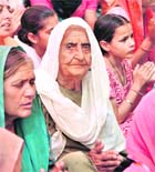 Dharmo Rani, along with family, prays for peace to her sons departed soul. 