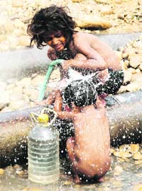 Just chill: With the mercury hitting the roof, these children have found a way to stay cool by playing with water from a leaking pipe in the Muthi area of Jammu