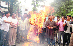 Traders burn an effigy of the Central government in protest against the price rise of fuel in Dehradun 