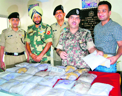 Mohammad Aquil, DIG, BSF, along with other officers displays the heroin seized near Chhana Pattan village on the India-Pakistan border on Saturday