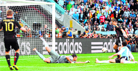 Germanys striker Miroslav Klose scores past Argentinas goalkeeper Sergio Romero his teams second goal during their quarterfinal in Cape Town on Saturday