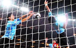 Uruguays striker Luis Suarez (L) stops the ball with his hand leading to a red card and a penalty for Ghana