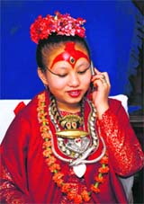 The living goddess Kumari Chanira Bajracharya, 15, talks on a phone at her residence in Patan on Saturday. The Nepali girl revered by many as a "living goddess" has become the first sitting deity to pass the high school leaving certificate exam