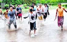 Residents play football in rain at a Sector 20 park, Chandigarh, on Sunday. 