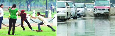 Youngsters enjoy the weather at Rajpath while cars wade through the waterlogged roads in New Delhi