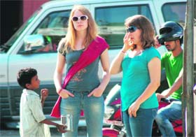 A young beggar asks for alms from two foreigners in Dehradun on Sunday.