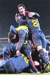 Spanish players jump on to David Villa after he scored Spains winner against Paraguay on Saturday.