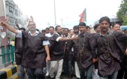 Wearing black gowns and chains, BJP workers staging a protest against price rise during the Bharat Bandh in Bathinda on Monday