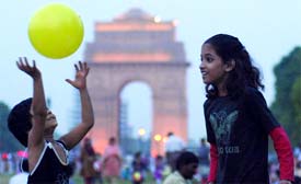 Children enjoy the rains at the India Gate.