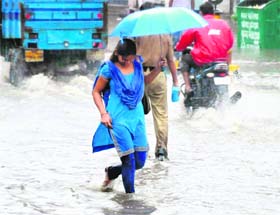 A girl wades through a flooded street
