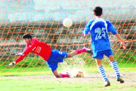 A goalkeeper attempts to save a goal at the Lala Nemi Dass Memorial Football Tournament in Dehradun