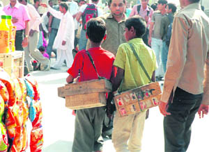 Shoe-shine boys await customers at the Gurgaon railway station.