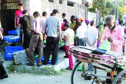 Rickshaw-pullers, autorickshaw drivers and destitutes collect Shatabdi food packets in the Rani Ka Bagh area, where food is prepared,in Amritsar on Tuesday.