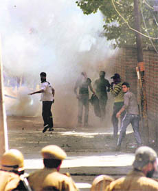 Protesters run for cover as the police fires teargas shells during a clash on Tuesday.