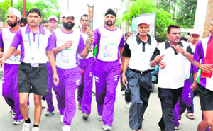 Players run with the Queens Baton of the Commonwealth Games after performing rituals at Har-ki-Pauri in Haridwar on Wednesday.