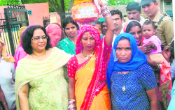 ADC Pankaj Chaudhary (left) with Saroj, who gave birth to a girl child, and other women during the kuan pujan ceremony at Bansudhar village in Sirsa.