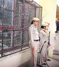 Police personnel stand guard near the damaged windowpanes of the Vice-Chancellor Office at HPU in Shimla on Wednesday. 