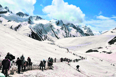 Pilgrims ride on horsebacks amid snowcapped mountains during the Amarnath yatra.