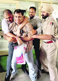 A policeman tries to overpower Anil Kumar who attempted suicide at the UT police headquarters in Sector 9, Chandigarh