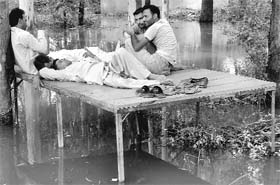 Three-wheeler operators take a break from work as the auto-rickshaws could not ply due to waterlogging at Dera Bassi