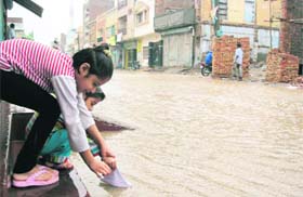 Woh Kagaz Ki KAshti, Woh Baarish Ka Paani": Children play in rainwater at Sirsa town