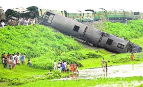 Onlookers and railway officials stand beside the derailed carriages of a passenger train after an explosion in Kokrajhar in Assam on Thursday. The powerful explosion on the track derailed the packed passenger train, leaving a five-year old boy dead and injuring seven others. 