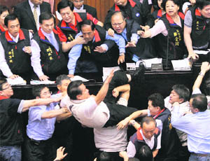 Opposition Democratic Progressive Party legislator Kuo Wen-chen falls off the podium while scuffling with ruling Nationalist Party legislators at the Legislative Yuan in Taipei on Thursday.